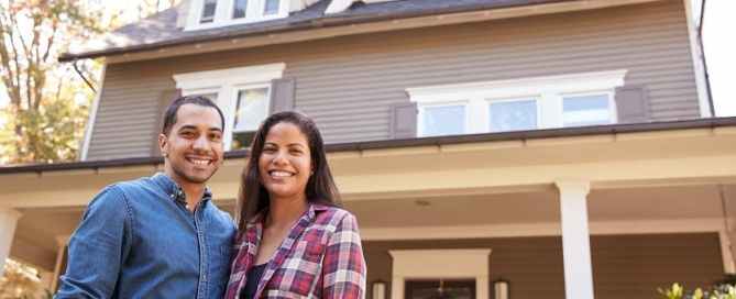 Couple standing in front of house